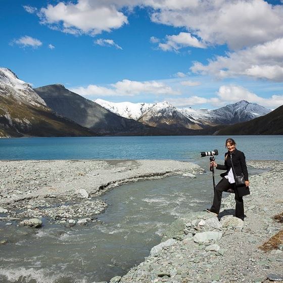 Photographer posing by lake and mountains in NZ